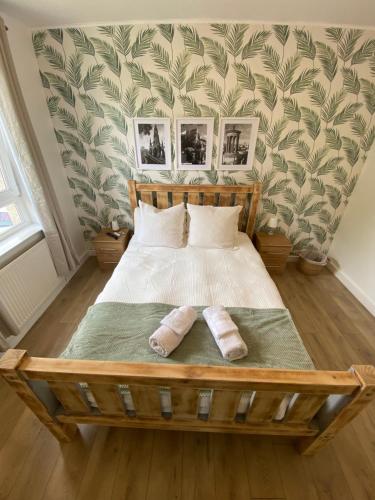 a bedroom with a wooden bed with two pillows at Edinburgh City Centre & Airport 2 Bedroom Apartment in Edinburgh