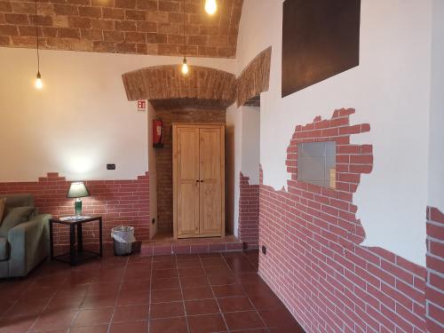 a room with a brick wall and a wooden door at Alloggio al binario 9 e tre quarti in Civitavecchia