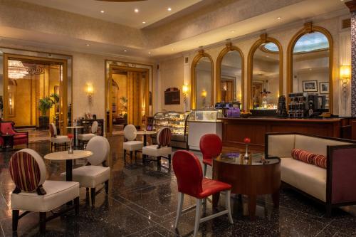 a restaurant with tables and chairs and a bar at The Roosevelt Hotel New Orleans - Waldorf Astoria Hotels & Resorts in New Orleans