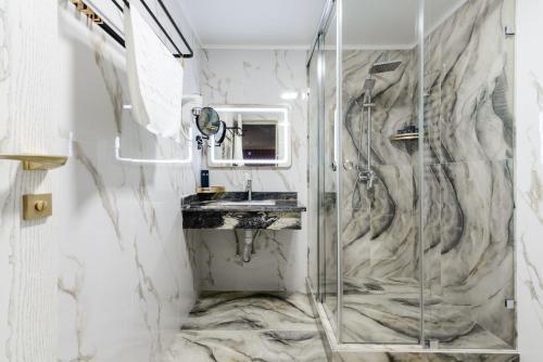 a bathroom with a shower and a sink at РИМ Grand Hotel in Almaty