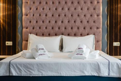 a bed with two pairs of slippers on it at РИМ Grand Hotel in Almaty