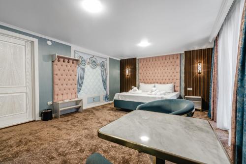 a hotel room with a bed and a table at РИМ Grand Hotel in Almaty