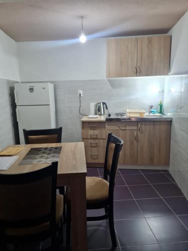 a kitchen with a table and chairs and a refrigerator at Apartmani Mihajlović in Herceg-Novi