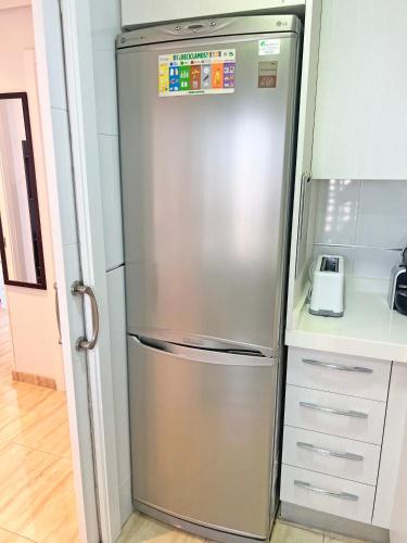 a stainless steel refrigerator in a kitchen at Playa y montaña 1ª linea Piscina Parking AC in El Campello