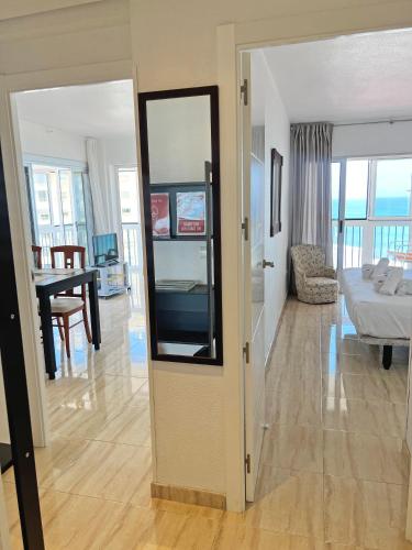 a living room with a mirror and a bedroom at Playa y montaña 1ª linea Piscina Parking AC in El Campello