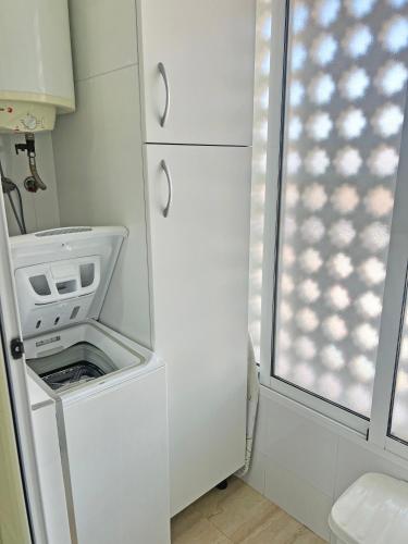 a white washer and dryer in a small bathroom at Playa y montaña 1ª linea Piscina Parking AC in El Campello