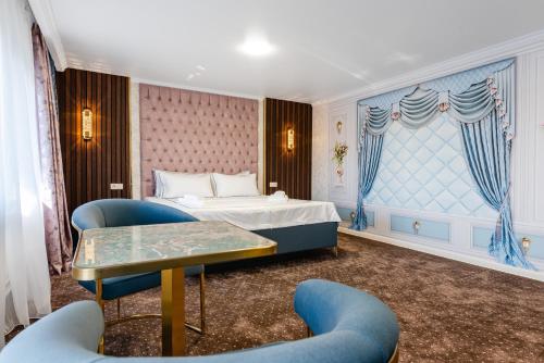 a hotel room with a bed and two chairs at РИМ Grand Hotel in Almaty