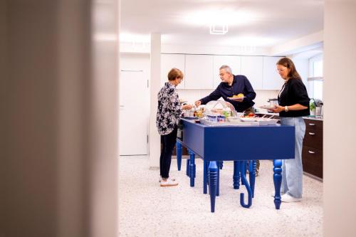 a group of people standing around a table in a kitchen at schlossmühle - lean luxury boutique hotel in Glottertal