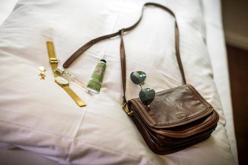a purse and other items on a bed at schlossmühle - lean luxury boutique hotel in Glottertal