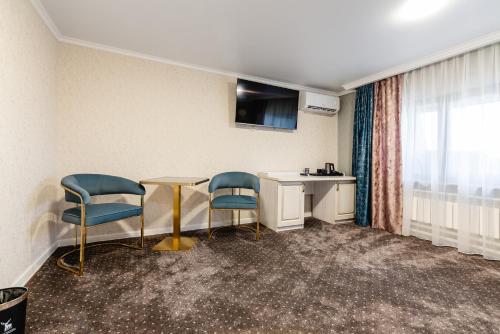 a waiting room with two chairs and a table at РИМ Grand Hotel in Almaty