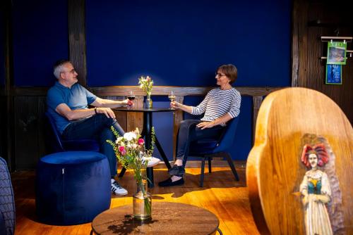a man and a woman sitting at a table at schlossmühle - lean luxury boutique hotel in Glottertal