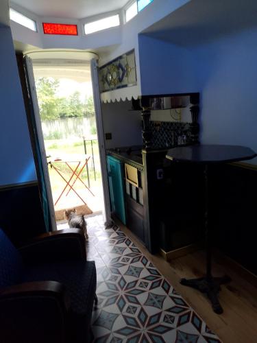 un chien se tient dans une cuisine avec une table dans l'établissement Roulotte L Aventura Art Deco, à Thurey