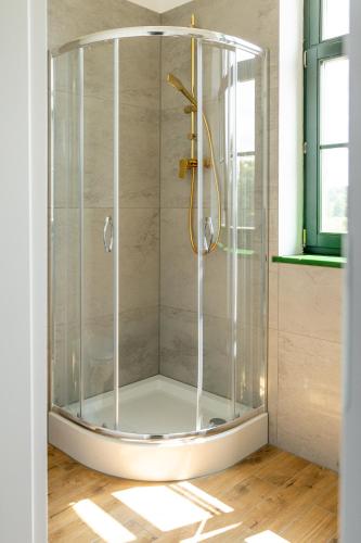 a shower with a glass enclosure in a bathroom at Hotel Mały Młyn in Stargard