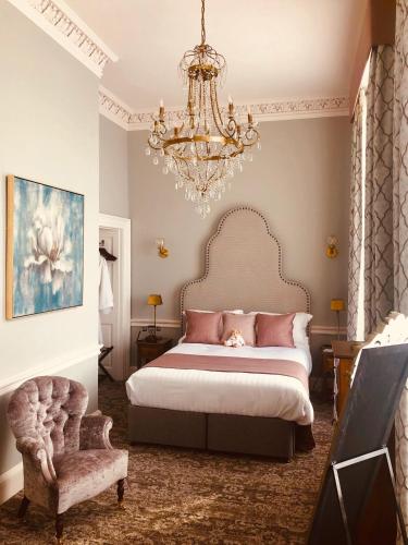 a bedroom with a large bed and a chandelier at Hawkstone Hall Hotel & Gardens in Shrewsbury