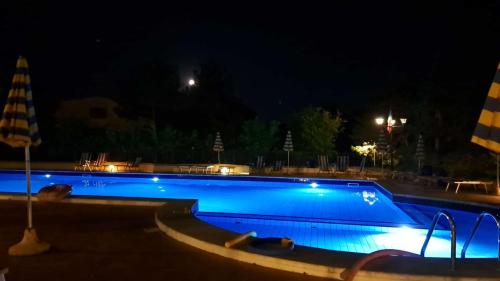 a swimming pool at night with blue lights at Residence Vigna del Mare in Gabicce Mare
