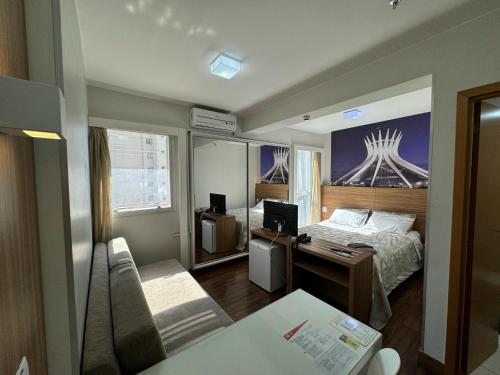 a bedroom with a bed and a desk with a computer at Suite Particular no Hotel S4 Águas Claras in Brasília