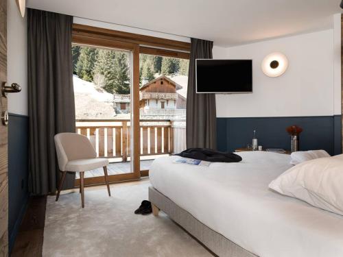 a hotel room with a bed and a balcony at Duplex plein sud à Courchevel Village - 4 pers - Pieds des pistes, balcons, parking, casier à skis - FR-1-631-73 in Courchevel