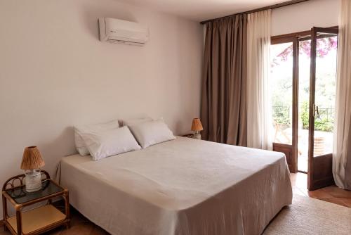 a bedroom with a large white bed and a window at Mount Minis - Casa Bruno in Syvota