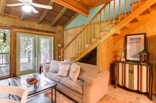 a living room with a couch and a staircase at Riverfront Anglers Cabin in Fairhope with Deck! in Fairhope