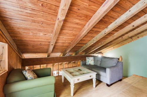 a living room with a couch and a table at Riverfront Anglers Cabin in Fairhope with Deck! in Fairhope