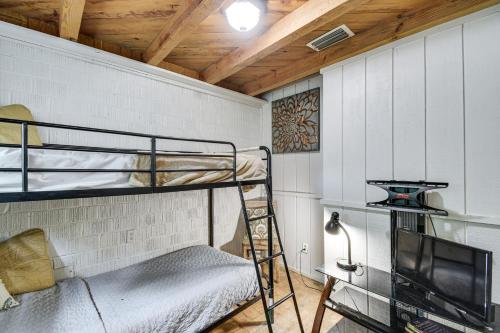a bunk room with a bunk bed and a tv at Riverfront Anglers Cabin in Fairhope with Deck! in Fairhope
