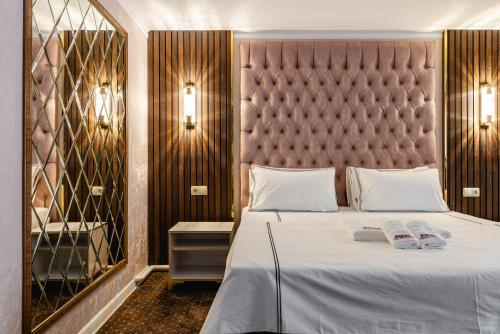 a bedroom with a large bed and a large mirror at РИМ Grand Hotel in Almaty