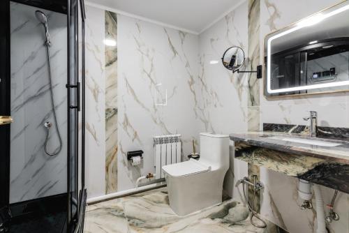 a bathroom with a toilet and a sink and a shower at РИМ Grand Hotel in Almaty