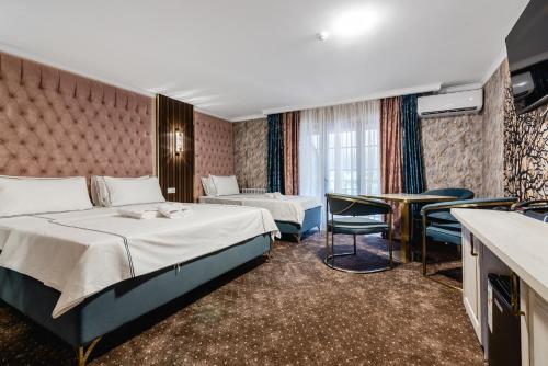 a hotel room with a bed and a table at РИМ Grand Hotel in Almaty