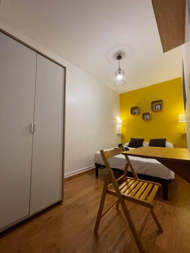 - une chambre avec un lit et un mur jaune dans l'établissement Blue Arena - Hyper Centre, à Nîmes