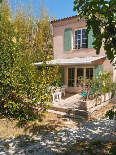 une maison rose avec un banc devant elle dans l'établissement VAR Studio Rez de chaussée - bord mer et campagne - au calme loin du béton, à La Garde