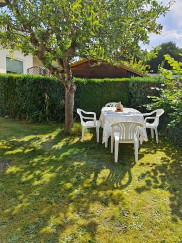 a table and chairs under a tree in a yard at Casa Nella - Komfortables Einzelhaus mit Garten in Halstenbek