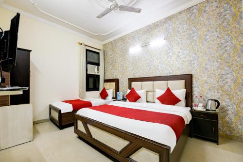 two beds in a hotel room with red pillows at Hotel Classic Park At Airport in New Delhi