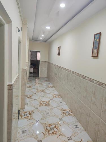 a hallway with a tiled floor and a wall at Jijel in Jijel