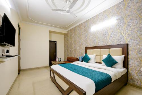 a bedroom with a large bed with blue pillows at Hotel Classic Park At Airport in New Delhi