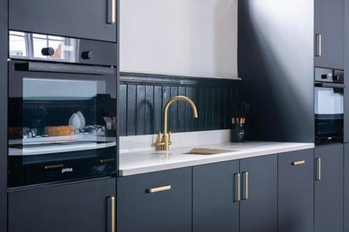 a kitchen with blue cabinets and a sink and a sink at The Great Hall, Edwinstowe Hall in Edwinstowe