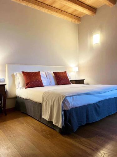 a bedroom with a large bed with red pillows at Villa Maria Luigia in San Biagio di Callalta