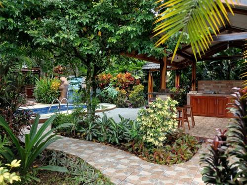 a garden with a pool and a person in the background at San Gabriel Apartments in Fortuna