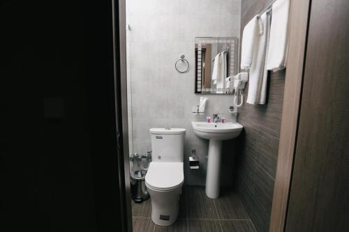 a small bathroom with a toilet and a sink at Grand Castle Hotel in Urganch