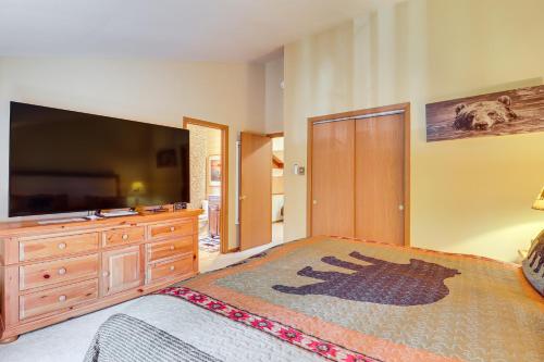 a bedroom with a bed and a dresser and a television at Walk to Restaurants Lake Harmony Townhome! in Lake Harmony