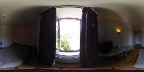 a large window with curtains in a room at Logis Hôtels - Hostellerie des Lauriers - Hôtel et Restaurant in Alban