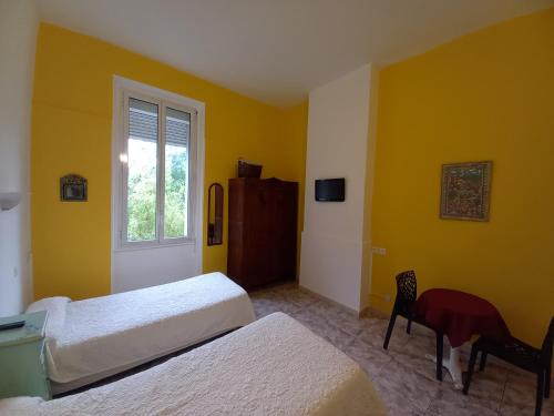 a bedroom with two beds and a window and a desk at Hotel Acapulco in Montpellier