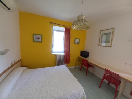 a bedroom with a white bed and two red chairs at Hotel Acapulco in Montpellier