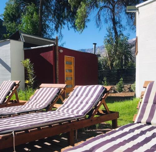 two deck chairs sitting in a yard next to a building at Organica Lodge Hotel Boutique in Vicuña