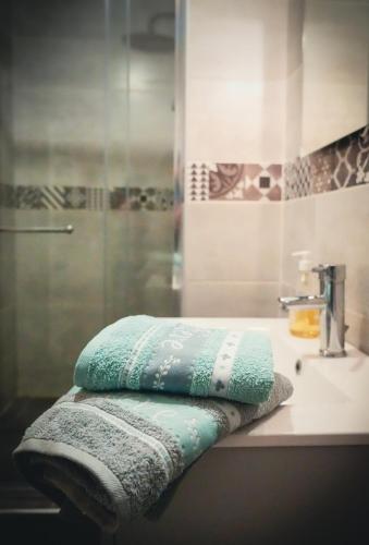 une salle de bain avec trois serviettes sur un lavabo dans l'établissement Le Victor Noir, à Chéroy