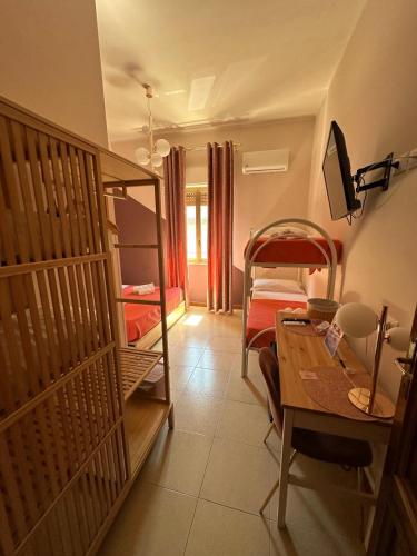 a room with a bedroom with bunk beds and a desk at B&B Elegance in Villa San Giovanni