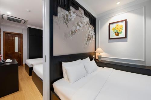 Postel nebo postele na pokoji v ubytování Serenata San de Hanoi Hotel