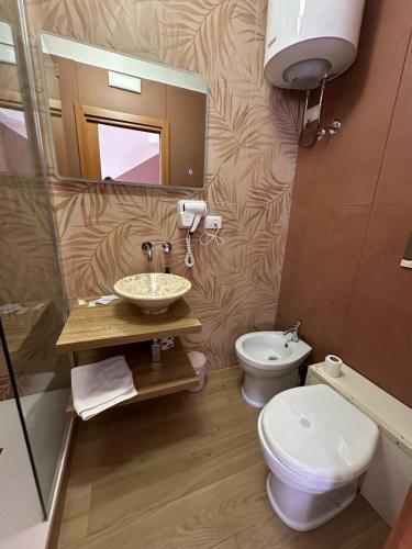 a bathroom with a sink and a toilet and a mirror at B&B Elegance in Villa San Giovanni