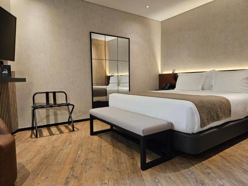 a bedroom with a large bed and a mirror at Hotel Principe Avila in Lisbon