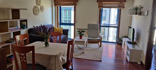 a living room with a table and chairs and a television at Piso Plaza 10 in Amés