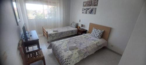 a small bedroom with two beds and a window at Casa da Lardosa in Lardosa